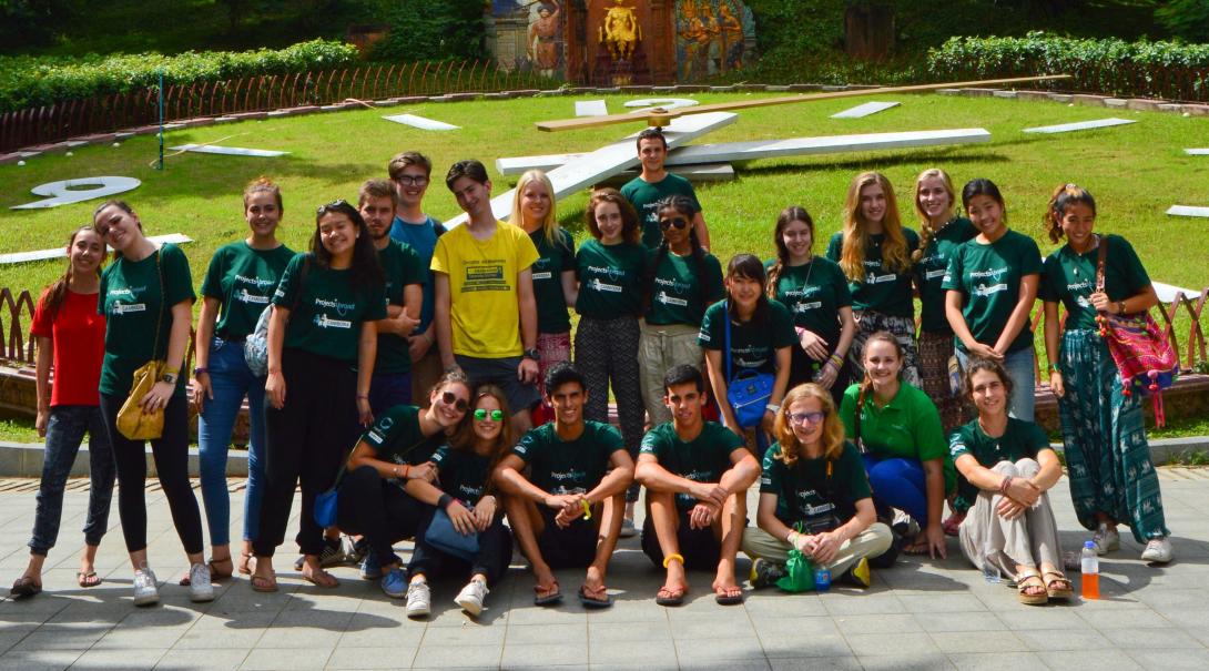 Young volunteers explore Cambodia during their team trip. A team of volunteers take a group photo outside Wat Phnom in Cambodia.